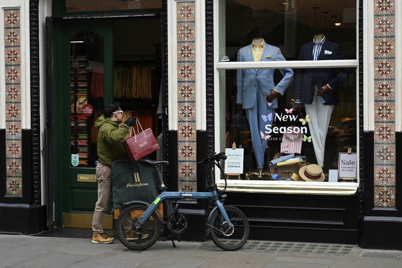 A man walks into a store with shopping bags in London, Britain, March 27, 2026. REUTERS/Jaimi Joy