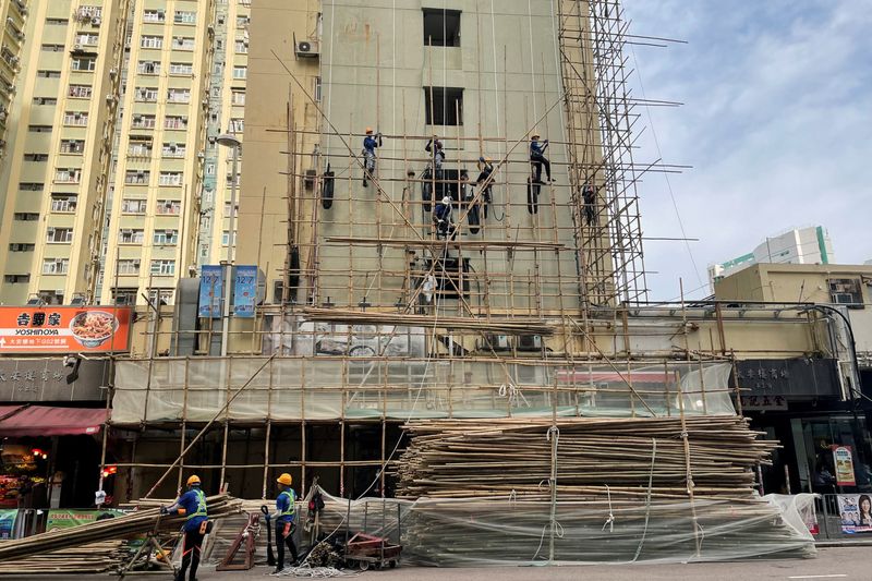 Construction workers set up bamboo scaffolding outside a building in Sai Wan Ho area in Hong Kong, China November 27, 2025. REUTERS/Sumeet Chatterjee
