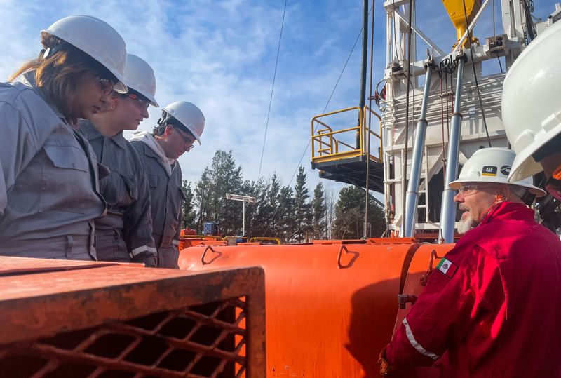 An instructor explains how a drilling rig works to Daiana Emilia Rodriguez and fellow students of the Vaca Muerta Institute in Neuquen province, which opened in March to address the shale formation's need for workers, in Vista Alegre, Argentina, July 15, 2026. Picture taken with a mobile phone. REUTERS/Leila Miller