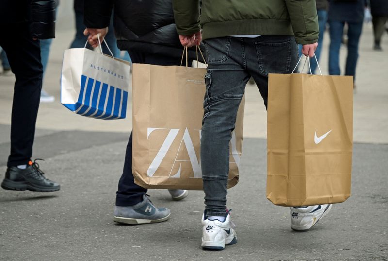 Shoppers carry bags as they walk along a busy shopping street in Hamburg, December 3, 2022. REUTERS/Fabian Bimmer/File Photo
