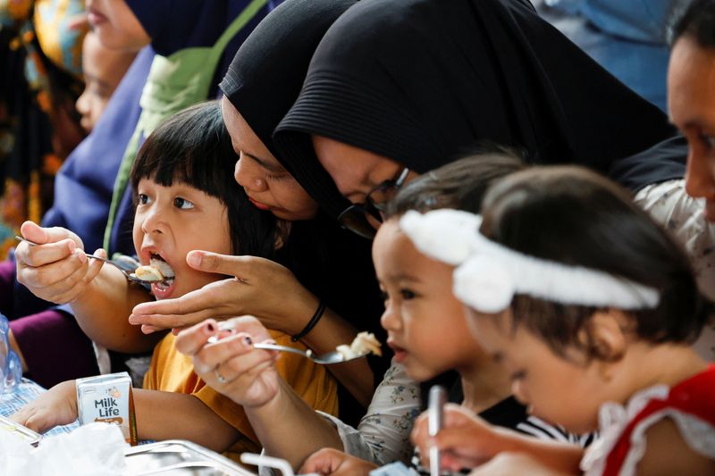 Kids eat meals from the free nutritious meals program in Jakarta, Indonesia, January 10, 2025. REUTERS/Ajeng Dinar Ulfiana