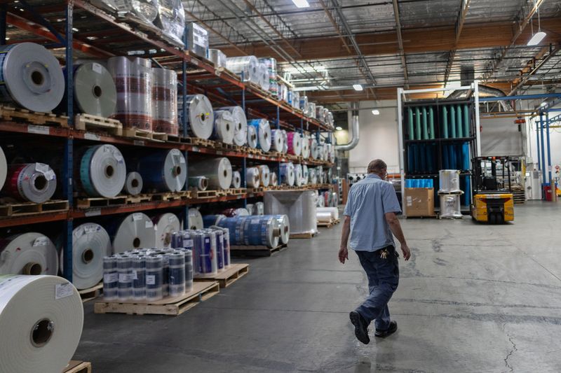 An employee at Emerald Packaging walks by rolls of plastic at the company’s facility in Union City, California, U.S., April 6, 2026. REUTERS/Carlos Barria