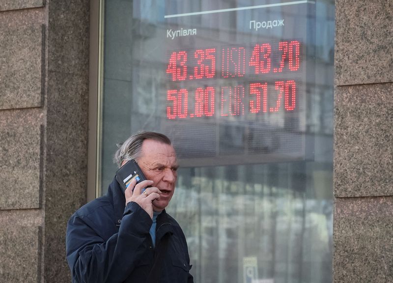 A man walks past a board showing currency exchange rates, amid Russia's attack on Ukraine, in Kyiv, Ukraine April 15, 2026. REUTERS/Gleb Garanich