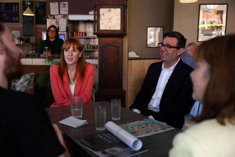 Britain's Prime Minister Andy Burnham and Britain's Housing Secretary Angela Rayner talk with local business owners and guests in The Hub cafe during a visit to Ilkeston, Derbyshire, Britain, August 11, 2026. TOBY SHEPHEARD/Pool via REUTERS