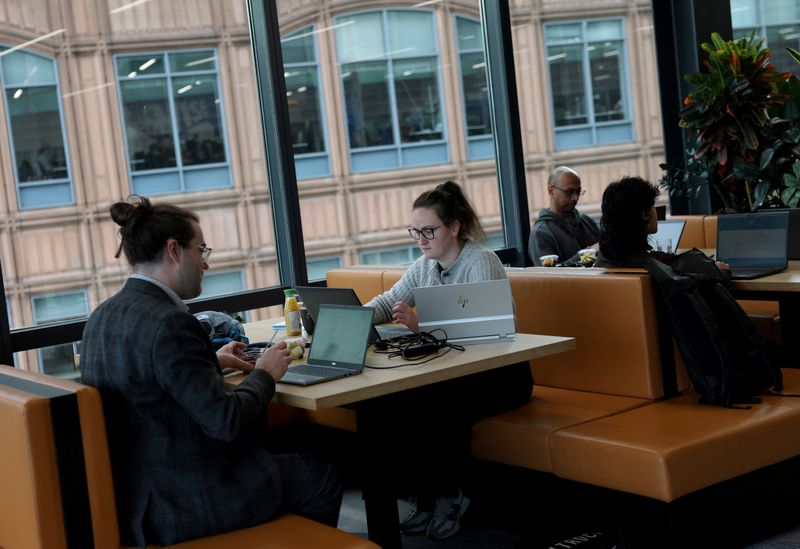 Employees work on laptops in the Moore Kingston Smith office in London, Britain, November 13, 2025. REUTERS/Hannah McKay