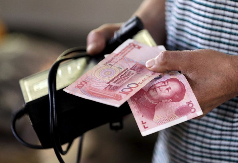 A customer holds a 100 Yuan note at a market in Beijing, August 12, 2015.  REUTERS/Jason Lee/File Photo
