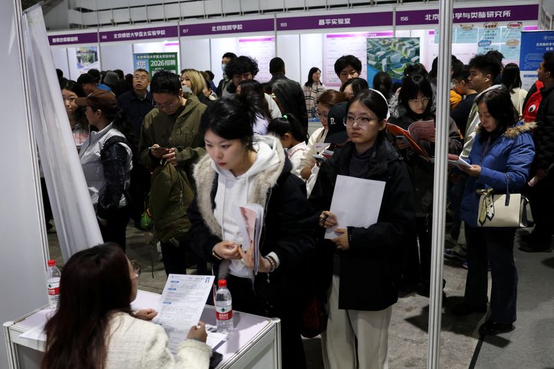 A recruiter attends to an applicant at a job fair in Beijing, China March 14, 2026. REUTERS/Florence Lo