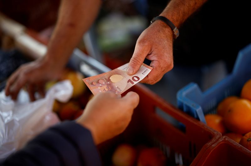FILE PHOTO: A shopper pays with a ten Euro bank note at a local market in Nantes, France, September 17, 2024. REUTERS/Stephane Mahe