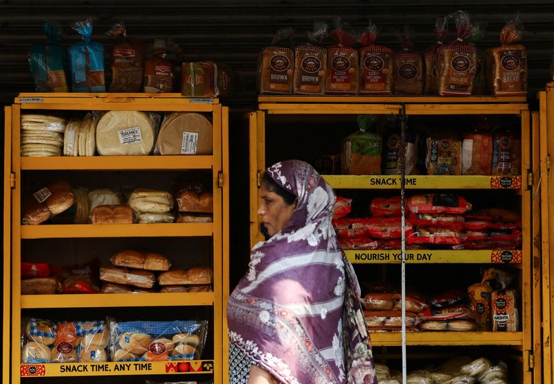 FILE PHOTO: A woman passes by a shop with stacked bread at a market in New Delhi, India, September 4, 2025. REUTERS/Anushree Fadnavis/File Photo