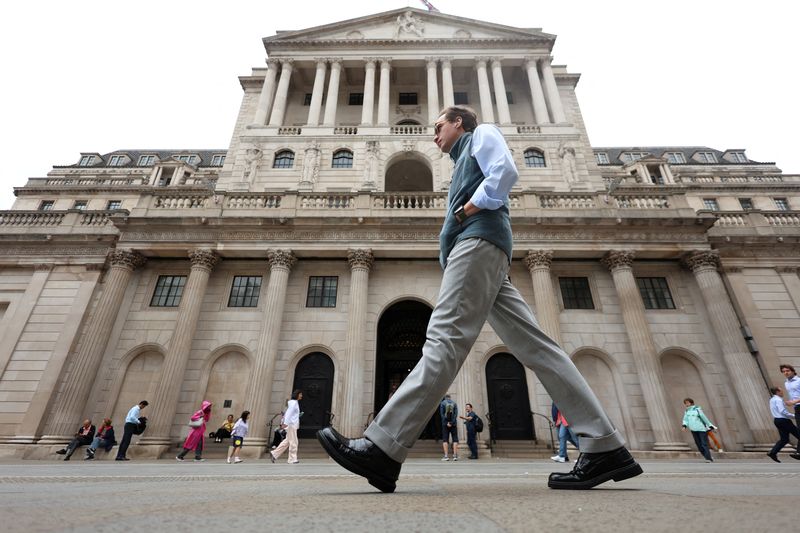 FILE PHOTO: A man walks past the Bank of England building in London, Britain, August 4, 2025. REUTERS/Hiba Kola/File Photo