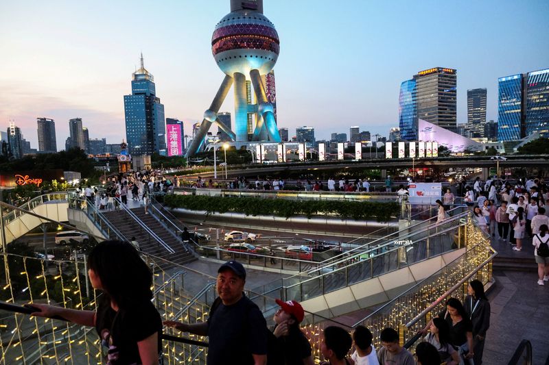 FILE PHOTO: People walk on a pedestrian bridge at Lujiazui financial district in Shanghai, China, July 14, 2025.  REUTERS/Go Nakamura/File Photo
