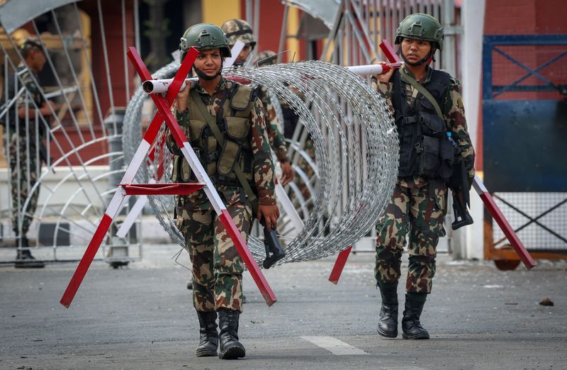 Nepali Army soldiers carry a concertina-barricade wire outside presidential building "Shital Niwas" in Kathmandu, Nepal, September 12, 2025. REUTERS/Adnan Abidi
