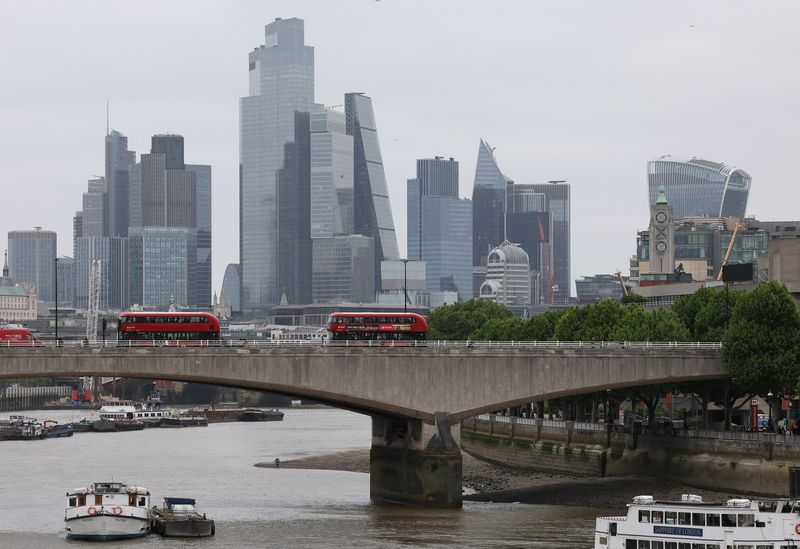 Buses cross Waterloo Bridge as skyscrapers in the City of London financial district are seen behind, in London, Britain, May 15, 2025. REUTERS/Toby Melville