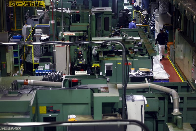 Workers walk between precision-machining machines for automotive parts inside a factory at Kyowa Industrial Co. in Takasaki, Gunma Prefecture, Japan April 11, 2025.  REUTERS/Issei Kato