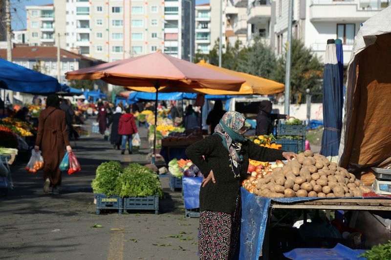 A vegetable vendor waits for customers at her stall in a women-led street market in Diyarbakir, Turkey December 22, 2021. Picture taken December 22, 2021. REUTERS/Sertac Kayar
