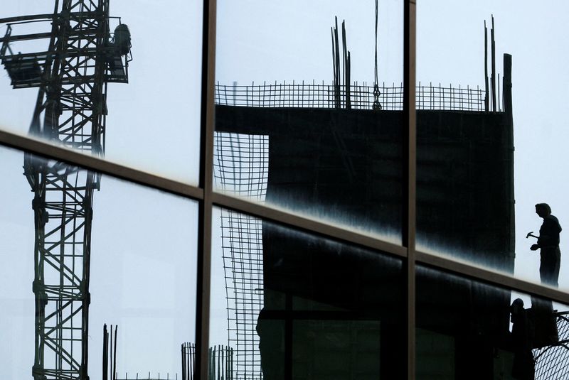 A construction worker is reflected in a window in central Sarajevo October 20, 2008. REUTERS/Danilo Krstanovic