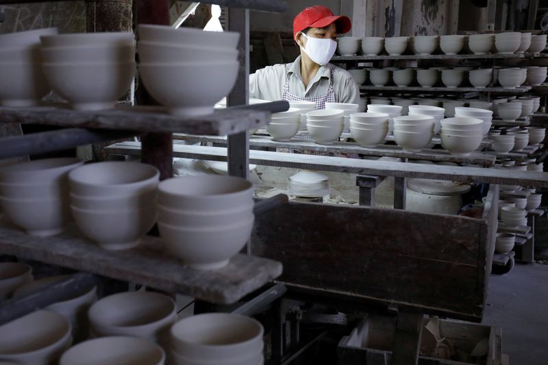 A woman works on ceramic products at an assembly of Hai Duong ceramic factory in Hai Duong province, Vietnam July 24, 2020. REUTERS/Kham