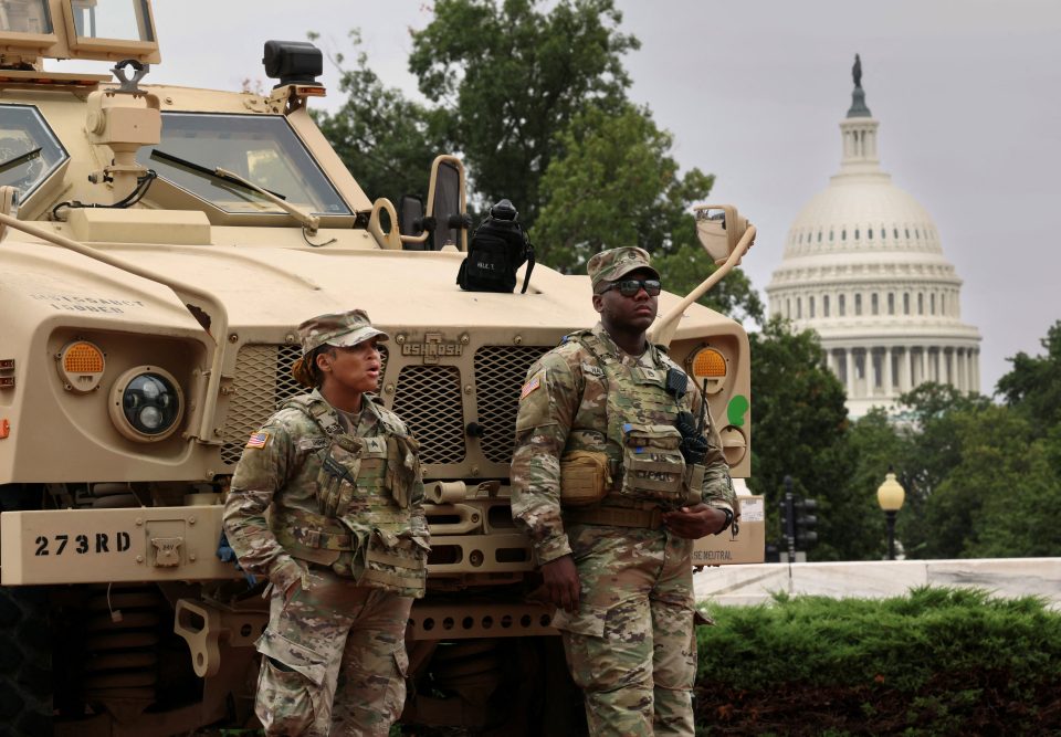 FILE PHOTO: With the dome of the U.S. Capitol in the background, members of the DC National Guard keep watch outside Union Station after U.S. President Donald Trump deployed the National Guard and ordered an increased federal law enforcement presence to assist in crime prevention, in Washington, D.C., August 19, 2025. REUTERS/Kevin Lamarque/File Photo