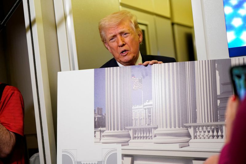 U.S. President Donald Trump talks to members of the media while holding up renderings of the planned White House ballroom, aboard Air Force One en route to Joint Base Andrews, Maryland, U.S., March 29, 2026. REUTERS/Elizabeth Frantz