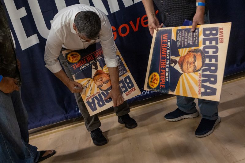 California gubernatorial candidate Xavier Becerra signs a banner during a campaign event at the Yosemite Hall of Sacramento State University in Sacramento, California, U.S., May 11, 2026. REUTERS/Carlos Barria