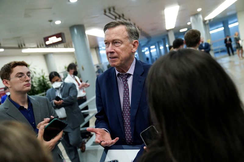FILE PHOTO: U.S. Senator John Hickenlooper (D-CO) speaks to members of the press while passing through the Senate subway at the U.S. Capitol in Washington, D.C., U.S., July 19, 2022. REUTERS/Sarah Silbiger/File Photo