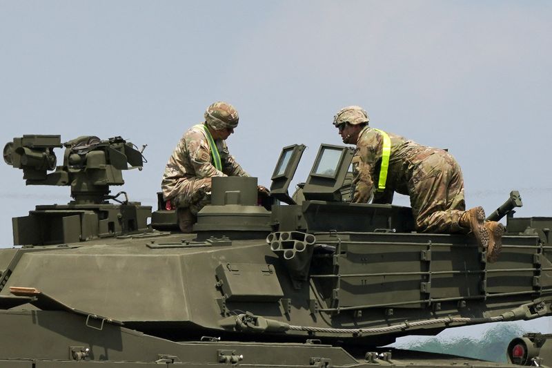 Military personnel work to offload heavy equipment and military vehicles to be used in the U.S. Army's 250th Birthday celebration and Parade in Washington, in Jessup, Maryland, U.S., June 9, 2025. REUTERS/Nathan Howard