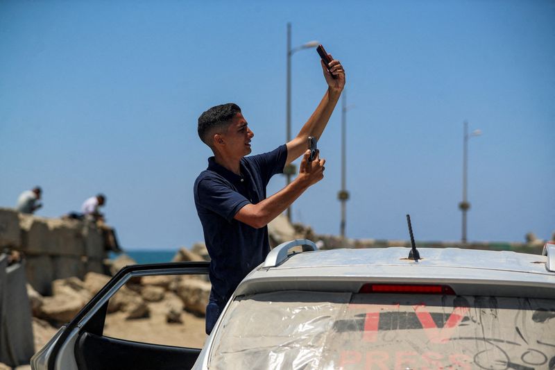 A Palestinian attempts to access the internet using eSIMs, after the Palestinian Telecommunications Regulatory Authority (TRA) announced on Thursday that internet and fixed-line communications services have been cut off, amid the Israeli offensive, at the seaport of Gaza City, June 12, 2025. REUTERS/Mahmoud Issa