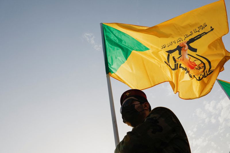 FILE PHOTO: A mourner attends the funeral of a commander from Iraq's Kataib Hezbollah armed group who was killed in what they called a "Zionist attack" in the Syrian capital Damascus on Friday, during a funeral in Baghdad, Iraq September 22, 2024. REUTERS/Thaier Al-Sudani/File Photo