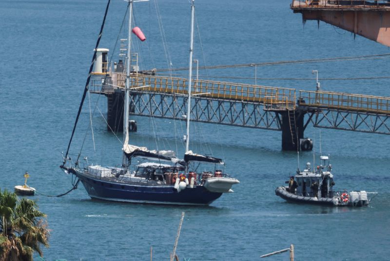 Gaza-bound British-flagged yacht "Madleen" is docked next to a military boat Ashdod port following a takeover by the Israeli army, in Ashdod, Israel, June 10, 2025. REUTERS/Nir Elias