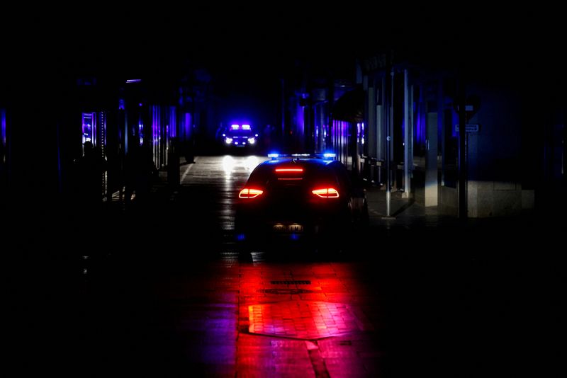 FILE PHOTO: Police car patrols a shopping street without electric lighting to prevent theft and looting in the stores during a power outage which hit large parts of Spain, in Ronda, Spain April 28, 2025. REUTERS/Jon Nazca/File Photo