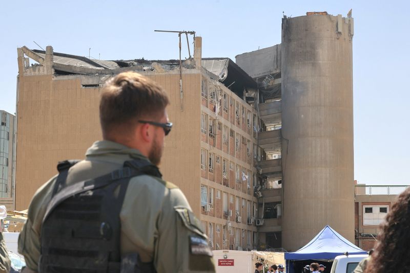 A member of the Israeli security forces walks near the Soroka Medical Center, the city's general hospital, at an impact site following a missile strike from Iran on Israel, in Beersheba, Israel on 19 June 2025.    Marc Israel Sellem/Pool via REUTERS