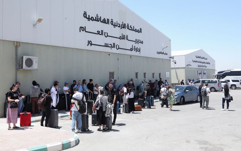 Expats, including diplomats from different nationalities, who were stranded in West Bank and Israel, wait as they hold belongings while being evacuated through the King Hussein Bridge crossing, in South Shuna, Jordan June 19, 2025. REUTERS/Alaa Al Sukhni
