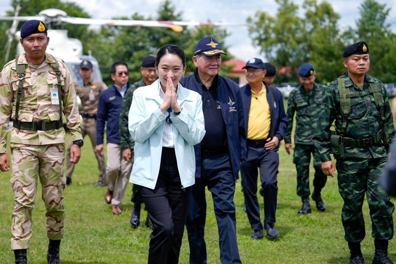 Thailand's Prime Minister Paetongtarn Shinawatra reacts as she walks with Thailand's Defence Minister Phumtham Wechayachai and Second Army Region Commander Lieutenant General Boonsin Padklang upon her arrival at Ubon Ratchathani, following a leak on Wednesday of a phone call between Paetongtarn and Cambodia's former PM Hun Sen, amid a border dispute between the two countries, at Morakot Operations Base, in Ubon Ratchathani province, Thailand, June 20, 2025. Government House of Thailand/Handout via REUTERS