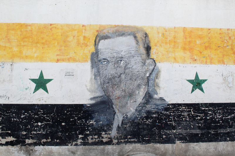 FILE PHOTO: A wall painted with a damaged drawing of ousted Syrian President Bashar al-Assad is pictured in the al-Qadam neighbourhood in Damascus, Syria, March 26, 2025. REUTERS/Firas Makdesi/File Photo