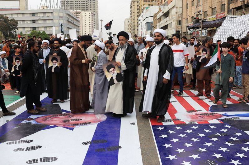 Pakistani Shi'ite Muslims walk over the posters depicting Israel and U.S. flags as they attend what they call 'down with Israel rally', following the Israeli strikes in Iran, in Karachi, Pakistan, June 22, 2025. REUTERS/Akhtar Soomro
