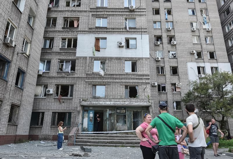Residents stand near an apartment building that was damaged during a Russian missile strike, amid Russia's attack on Ukraine, in Dnipro, Ukraine June 24, 2025. REUTERS/Mykola Synelnykov