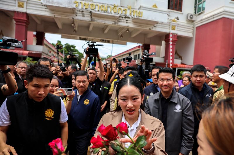 Thailand’s Prime Minister Paetongtarn Shinawatra receives roses from her supporters as she visits the Ban Khlong Luek Border Checkpoint on a Thailand-Cambodia border town of Aranyaprathet district, as she battles to stay in power after drawing sharp criticism of her handling of a border row with Cambodia, Sa Kaeo province, Thailand, June 26, 2025.  REUTERS/Athit Perawongmetha