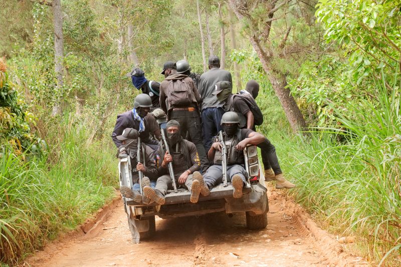 FILE PHOTO: Members of a neighbourhood watch drive up a hill while patrolling a residential area after gangs torched homes, amid a surge in violence that has displaced approximately 1.3 million people in six months, according to U.N. estimates, in Furcy, Haiti June 24, 2025. REUTERS/Jean Feguens Regala/File Photo