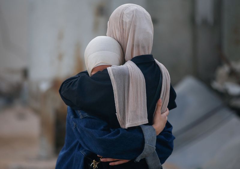 Women embrace, while mourning loved ones, during the funeral of Palestinians killed by Israeli fire yesterday, as they sought aid in northern Gaza, according to Gaza's health ministry, at Al-Shifa Hospital, in Gaza City, June 19, 2025. REUTERS/Mahmoud Issa/ File Photo