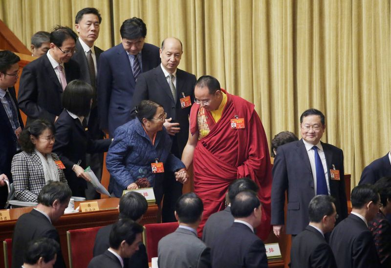FILE PHOTO: Gyaltsen Norbu, the 11th Panchen Lama and a delegate of Chinese People's Political Consultative Conference (CPPCC), speaks to an elderly delegate as they leave after the opening session of the Chinese People's Political Consultative Conference at the Great Hall of the People in Beijing, China, March 3, 2019. REUTERS/Jason Lee/File Photo