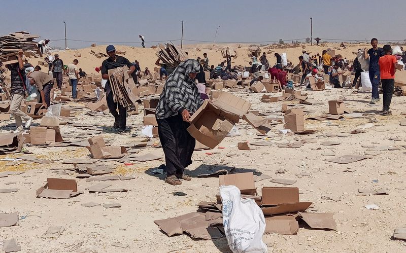 FILE PHOTO: Palestinians gather to collect what remains of relief supplies from the distribution center of the U.S.-backed Gaza Humanitarian Foundation, in Rafah, in the southern Gaza Strip, June 5, 2025. REUTERS/Stringer/File Photo