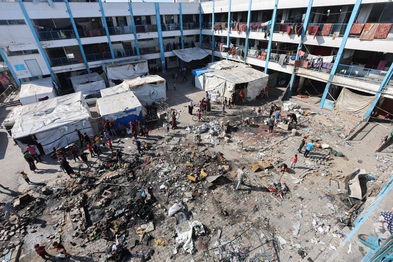 Palestinians inspect the site of an overnight Israeli strike on a school sheltering displaced people, in Bureij refugee camp, in the central Gaza Strip, July 8, 2025. REUTERS/Ramadan Abed