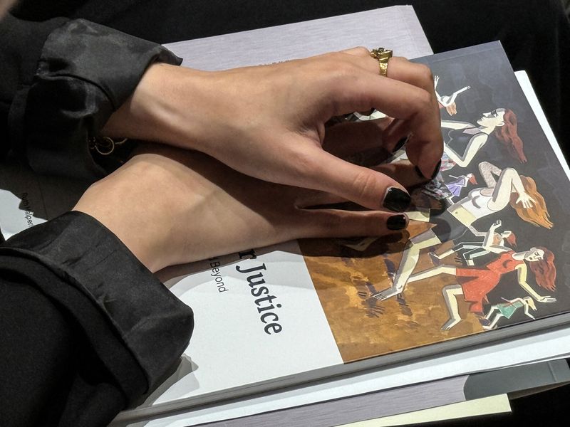 A woman places her hands on a copy of the report titled 'A Quest for Justice' on Sexual Violence during the Oct.7 2023 Hamas attack at the President House in Jerusalem July 8, 2025, REUTERS/ Dedi Hayun
