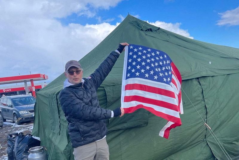 Israeli-American businessman Moti Kahana holds a flag during a mission to evacuate 200 Jews in Chernivtsi, Ukraine, March, 2022, in this handout picture released to Reuters July 10, 2025. GDC Inc./Handout via REUTERS