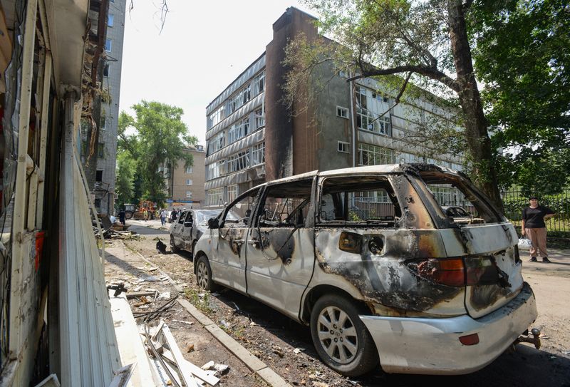 A woman stands next to damaged cars following what local authorities said was a Ukrainian drone attack, amid the Russia-Ukraine conflict, in the town of Voronezh, Russia July 15, 2025.  REUTERS/Stringer