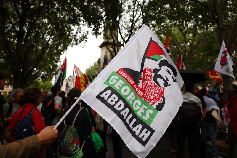 FILE PHOTO: A protester holds a flag with the slogan "Freedom for Georges Abdallah" during a demonstration to demand the immediate and unconditional release of Georges Ibrahim Abdallah, a Lebanese militant held in France since 1984, on the eve of a French appeals court ruling on his conditional release, in Paris, France, July 16, 2025.  REUTERS/Abdul Saboor/File photo