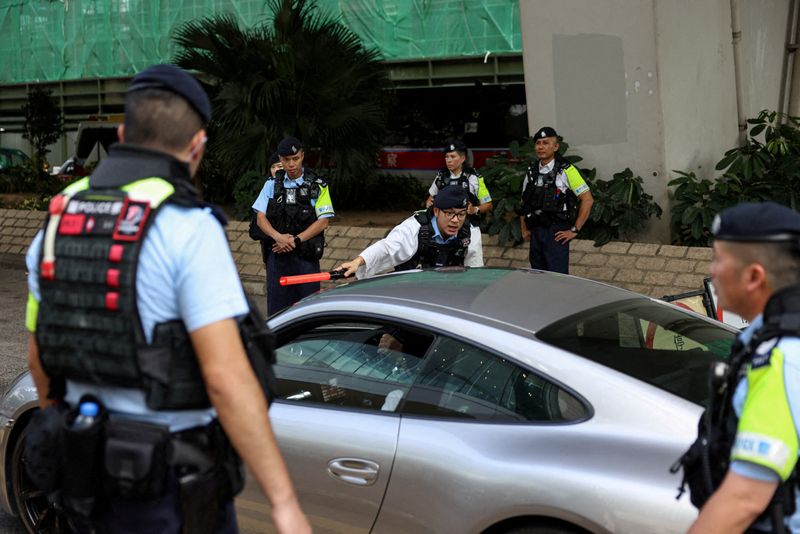 FILE PHOTO: Police officers stand guard at the West Kowloon Magistrates' Courts building, ahead of hearing appeals from 12 jailed pro-democracy activists in Hong Kong, China, July 14, 2025. REUTERS/Tyrone Siu/File Photo