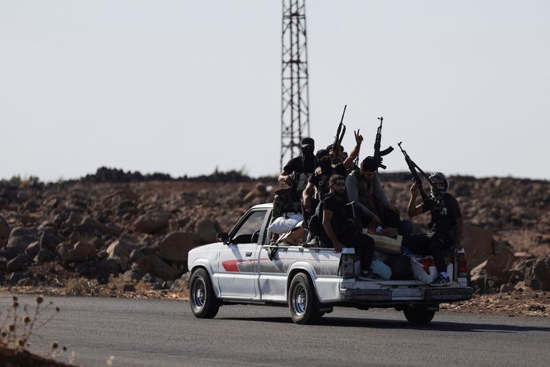 Bedouin fighters ride a car, following renewed fighting between Bedouin fighters and Druze gunmen, despite an announced truce, in Sweida, Syria July 18, 2025. REUTERS/Khalil Ashawi