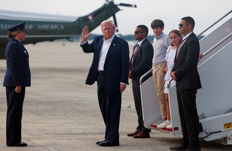 U.S. President Donald Trump, accompanied by his grandchildren Chloe Trump and Spencer Trump, waves as he disembarks from Air Force One as he returns from Scotland, Britain, at Joint Base Andrews, Maryland, U.S., July 29, 2025. REUTERS/Evelyn Hockstein