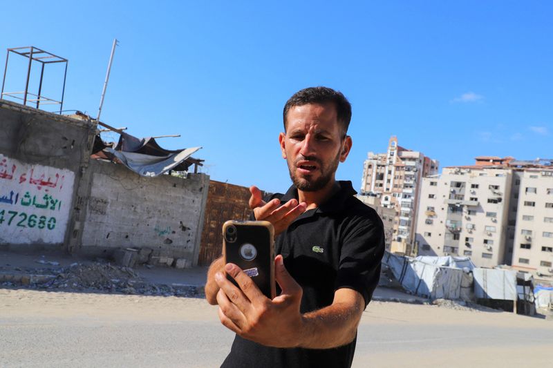 Hearing-impaired Palestinian influencer Basem Al-Habel, who turned to social media to document the war in Gaza through sign language, reaching a wide range of followers from both inside and outside of the enclave, films himself in Gaza City August 5, 2025.REUTERS/Ebrahim Hajjaj